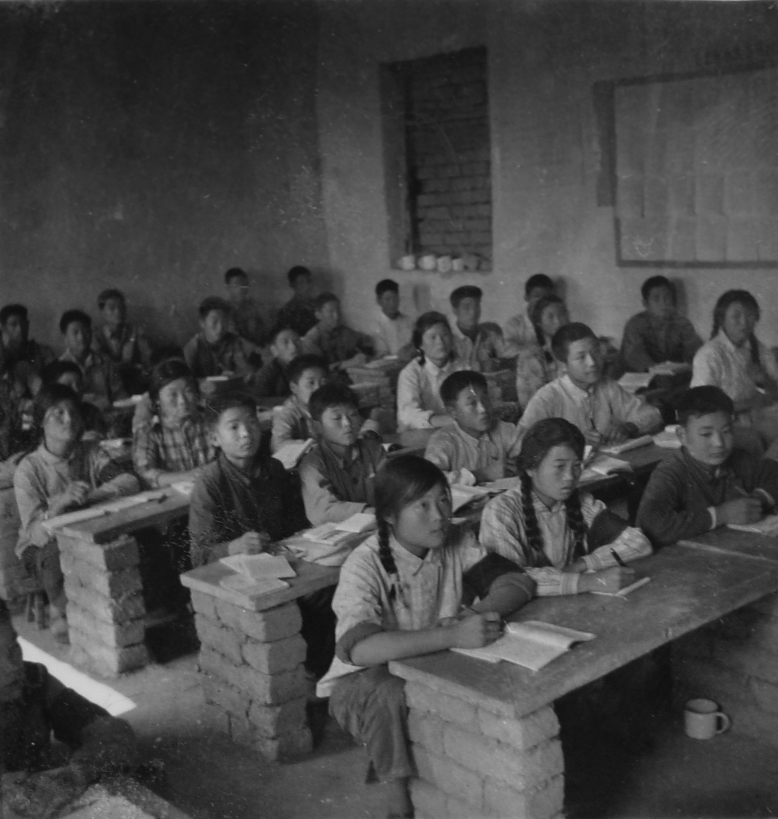 校舍改造前农村小学生用土台子当课桌凳上课